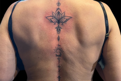 delikatny-kobiecy-tatuaz-na-plecach-z-kwiatem-lotosu