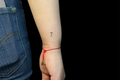 maly-tatuaz-na-nadgarstku-siodemka-wykonana-w-minimalistycznym-stylu